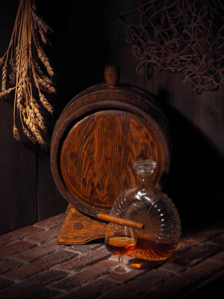 istock Glass of cognac with barrel in cozy cellar 854312748