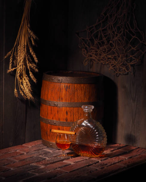 istock Glass of cognac with barrel in cozy cellar 854312864