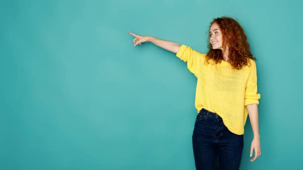 istock Excited woman shows something, point finger up 854315764