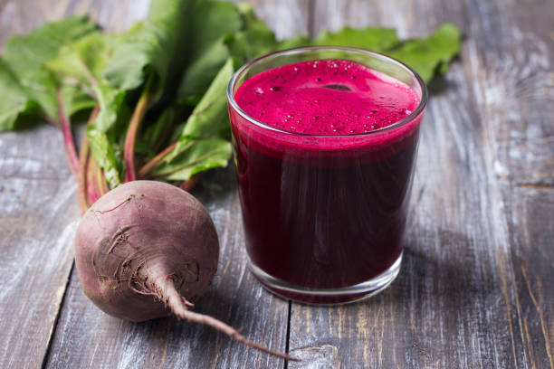 Fresh beet juice in glass with a straw on a wooden background Fresh beet juice in glass with a straw on a wooden background, selective focus. Healthy detox diet beta vulgaris stock pictures, royalty-free photos & images