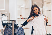 Young woman choosing clothes in the store