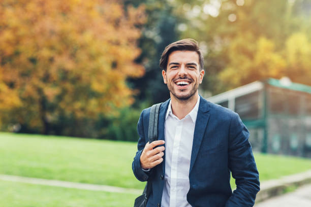 istock Smiling man walking in a city park 854321500
