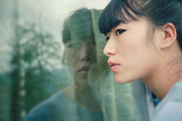 istock Asian young woman with his reflection in glass window. 854322284
