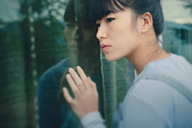istock Asian young woman with his reflection in glass window. 854324866