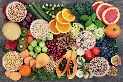 Overhead view of a large group of healthy food for a well balanced diet arranged side by side on black background. High resolution 42Mp studio digital capture taken with SONY A7rII and Zeiss Batis 40mm F2.0 CF lens