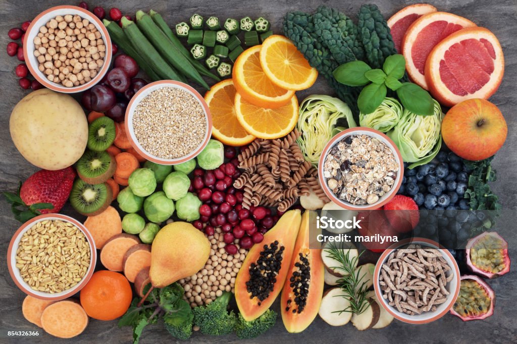 Health Food with High Fiber Content Health food concept for a high fiber diet with fruit, vegetables, cereals, whole wheat pasta, grains, legumes and herbs. Foods high in anthocyanins, antioxidants, smart carbohydrates and vitamins on marble background top view. Dietary Fiber Stock Photo