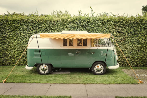 1950s Volkswagen Type 2 (T1) Transporter  Kombi or Microbus campervan with a sunblind parked in a park. The Volkswagen Transporter is a popular van to use as a camper and was delivered originally as a camper van, but many have been converted later. The car is on display during the 2017 Classic Days at Schloss Dyk in Juchen, Germany.