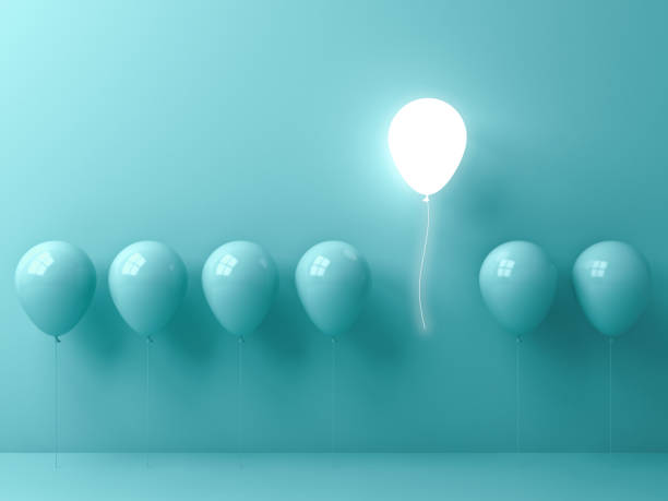 Stand out from the crowd and different concept , One light balloon flying away from other green balloons on light green pastel color wall background with window reflections and shadows . 3D rendering stock photo