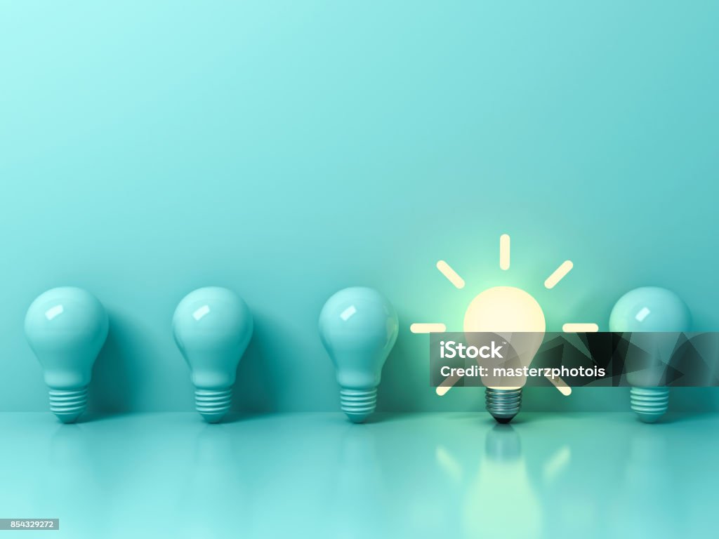 One glowing idea bulb standing out from unlit incandescent bulbs on light green pastel color background with reflection and shadow , individuality and different creative idea concepts . 3D rendering One glowing idea bulb standing out from unlit incandescent bulbs on light green pastel color background with reflection and shadow , individuality and different creative idea concepts . 3D rendering. Light Bulb Stock Photo