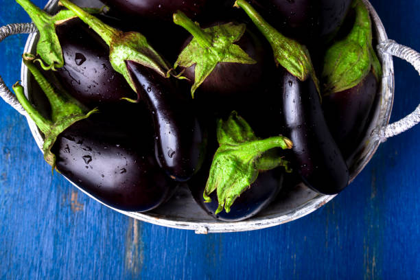 istock Fresh eggplant in grey basket on blue wooden table.Rustic background. Top view. Copy space. Vegan vegetable. 854340738