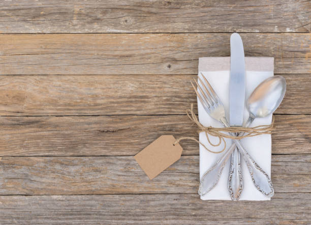 istock Silverware with napkin and empty tag on wooden table 854341056