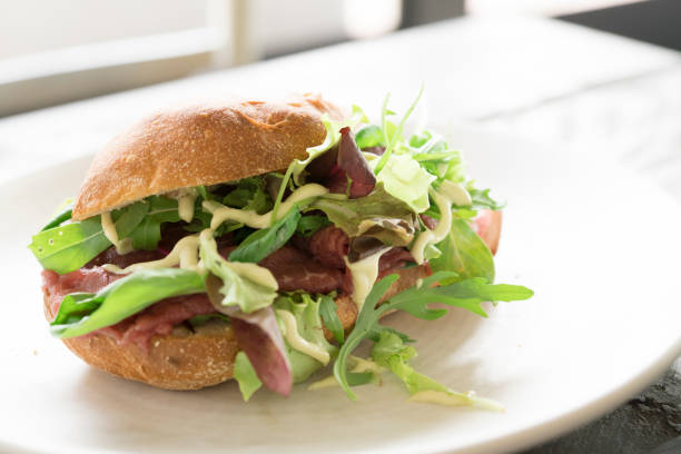 istock bread with beef carpaccio, salad and sauce on white plate 854342092