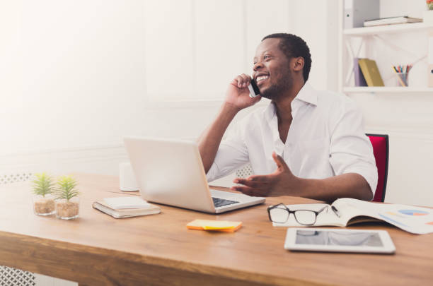 istock Young black businessman call mobile phone in modern white office 854345358