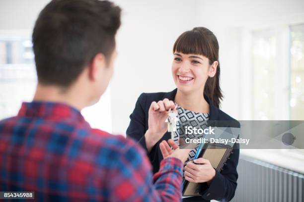 Man Collecting Keys To New Home From Female Real Estate Agent Stock Photo - Download Image Now