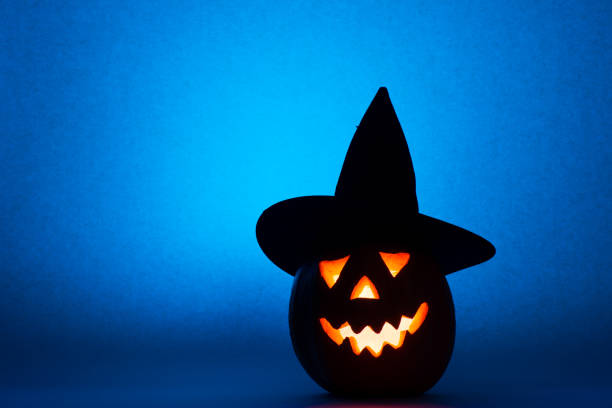 istock Happy Halloween pumpkin in hat, funny face on blue background 854358652