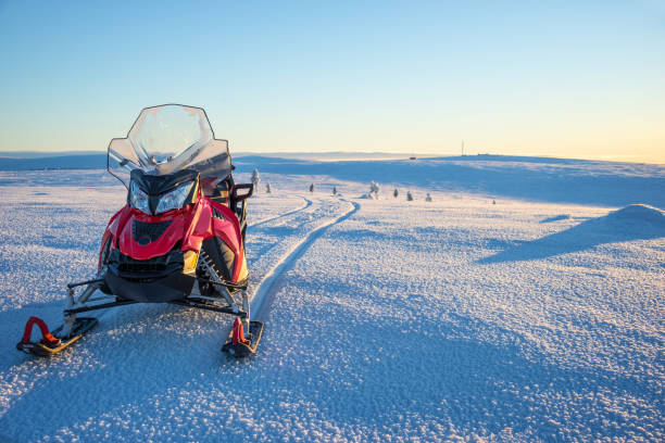 moto de nieve en un paisaje cubierto de nieve en laponia, cerca de saariselka, finlandia - motoesquí fotografías e imágenes de stock