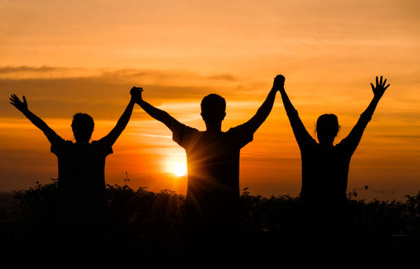 istock Happy people make high hand at sunset 854363824