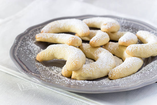 traditional german christmas cookies vanilla crescent vanillakipferl with icing poweder on gray plate. close up. selective focus. white background. - cookie christmas shortbread food imagens e fotografias de stock