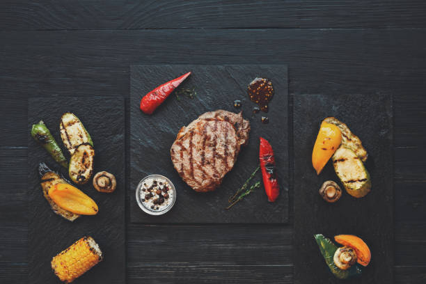 istock Grilled beef steak on dark wooden table background, top view 854370834