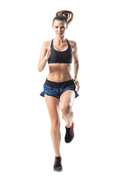 istock Front view of young pretty female athlete sprinting towards camera. 854373970