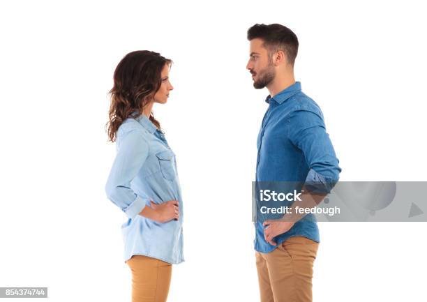 Serious Casual Couple With Hands On Waist Facing Each Other Stock Photo - Download Image Now