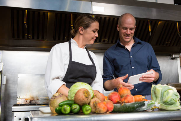 Restaurant manager working together with a professional female chef