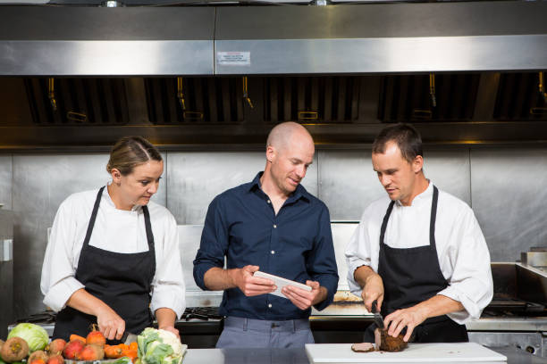 restaurant manager works with his professional chef's - home economics class imagens e fotografias de stock