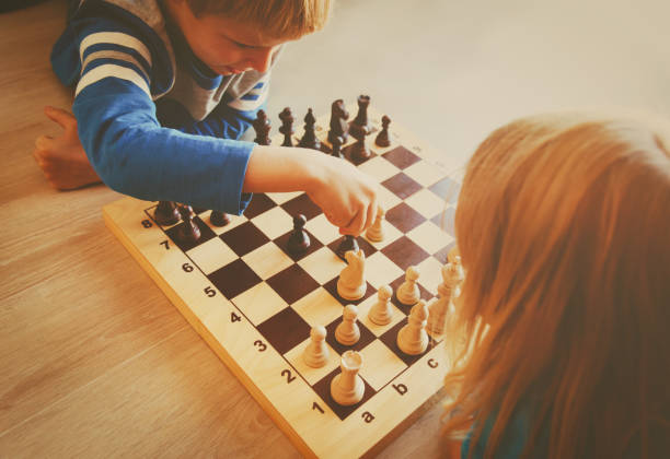 istock little boy and girl play chess 854377878