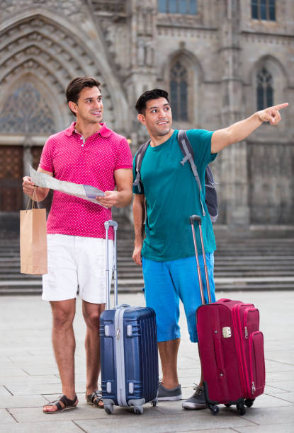 Men tourists are watching in map and searching way for walking in the unknown city