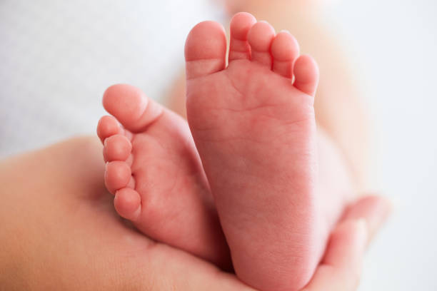 istock Baby feet in mother's hands 854386316