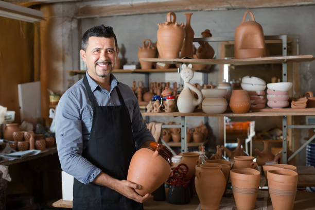 istock Happy man artisan having ceramics in hands 854392540