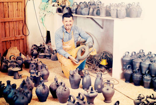 istock Mature male artisan with ceramic vases 854392714