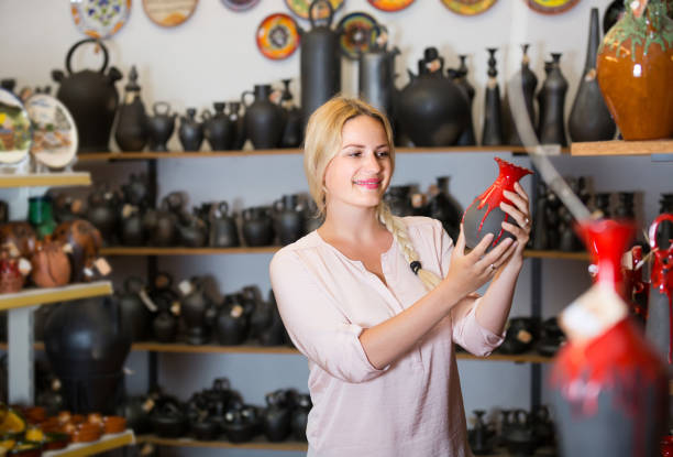 istock young woman selecting ceramics with red enamel in atelier 854392780