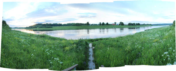Wide view of village on riverbank in summer