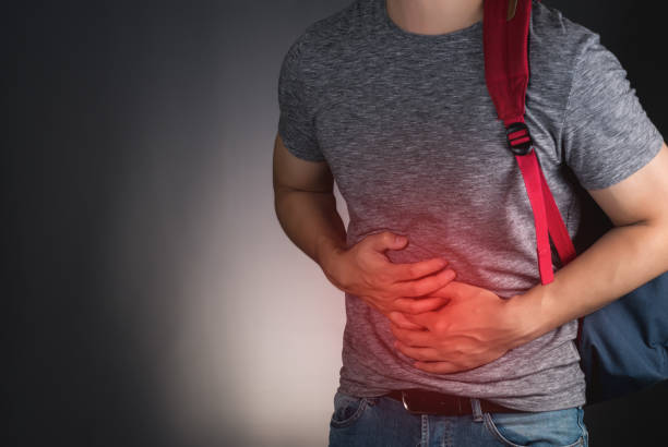 istock asian student man suffering form stomachache 854397824