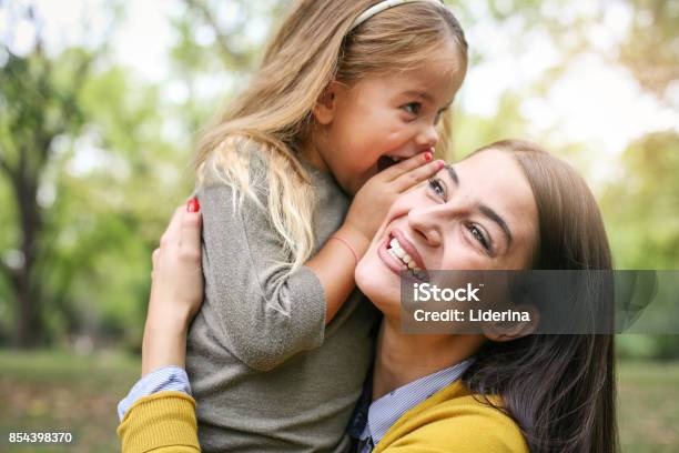 Mother And Daughter Outdoors In A Meadow Daughter Whispering To Her Mother Secret Stock Photo - Download Image Now