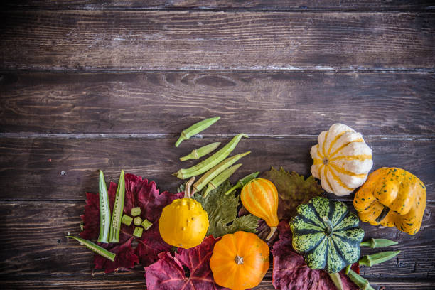 istock Decorative multicolored pumpkins and okra on rustic wooden table 854405032