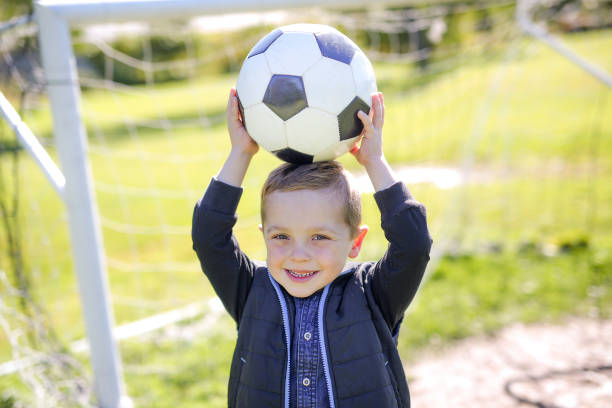 istock boy with soccer ball in park 854406044