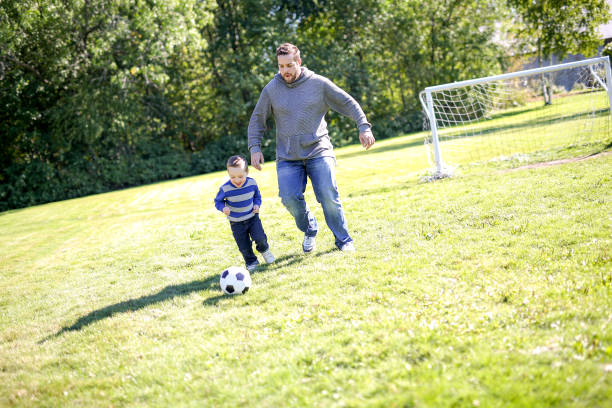 istock Father and Son Playing Ball in The Park 854406196