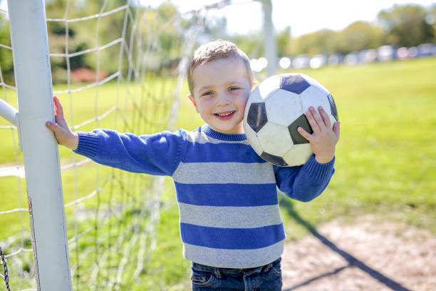 istock boy with soccer ball in park 854409004