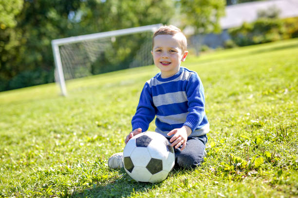 istock boy with soccer ball in park 854409050