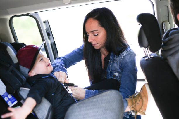 istock Mother securing her boy in the car seat in 854409106