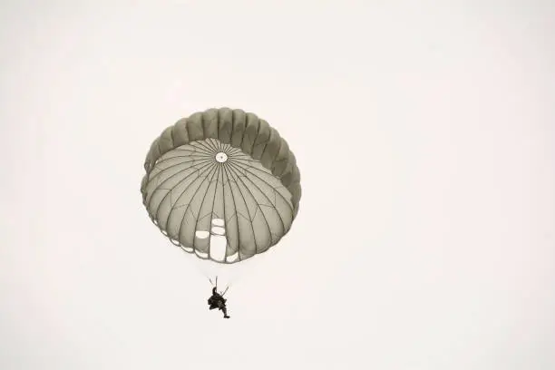 Photo of Parachute soldiers in the sky.