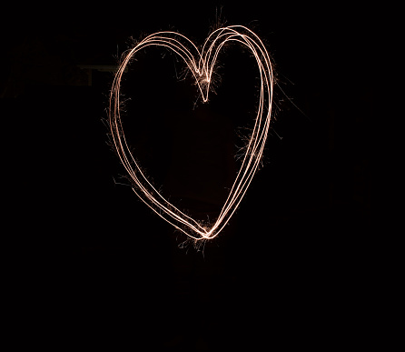 Shot of a hart being drawn with a sparkler through use of light painting outside at night