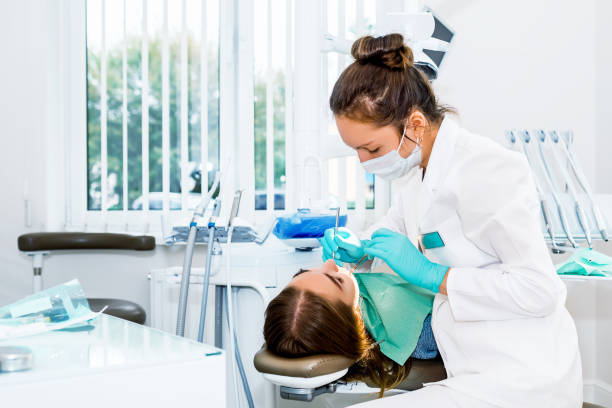 dentista donna che controlla i denti del paziente con le parentesi graffe presso lo studio della clinica dentale. medicina, concetto di odontoiatria. attrezzature dentali - bocca umana foto e immagini stock