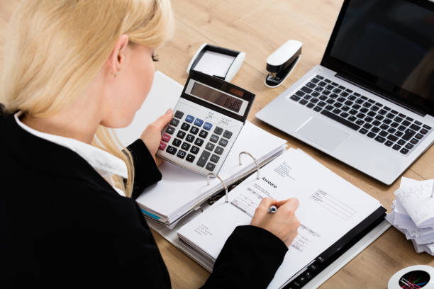 istock Businesswoman Calculating Invoice In Office 854424356