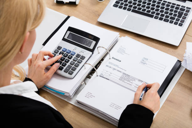 istock Businesswoman Calculating Invoice In Office 854424366