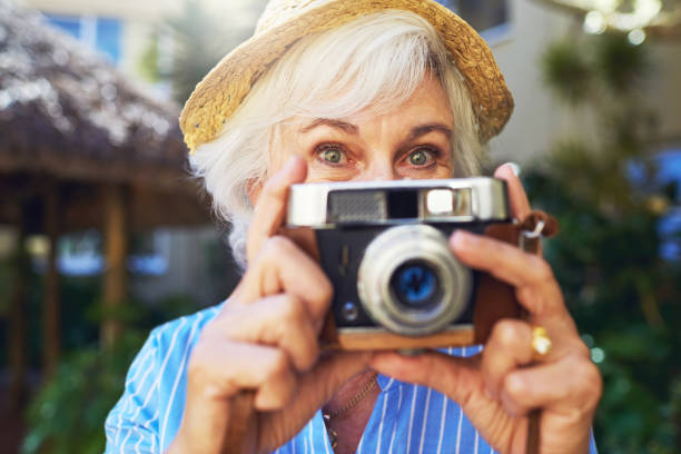 Capturing my retirement everyday Cropped shot of a senior woman taking photographs at home camera covers pictures stock pictures, royalty-free photos & images