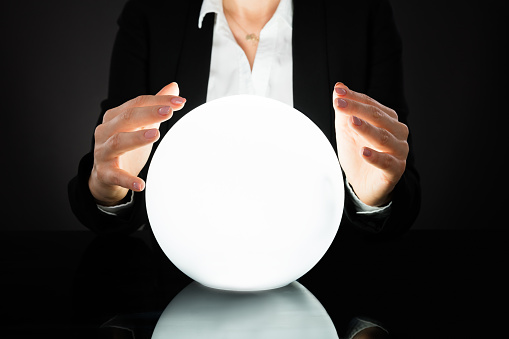 Businesswoman Hands On Crystal Ball On Black Background. Fortune Teller Predicting Future