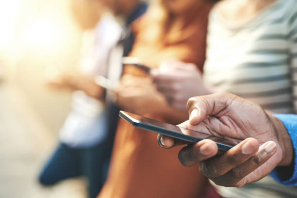 These days fingers do the talking Shot of an unrecognizable group of people social networking outside telecommunications equipment stock pictures, royalty-free photos & images